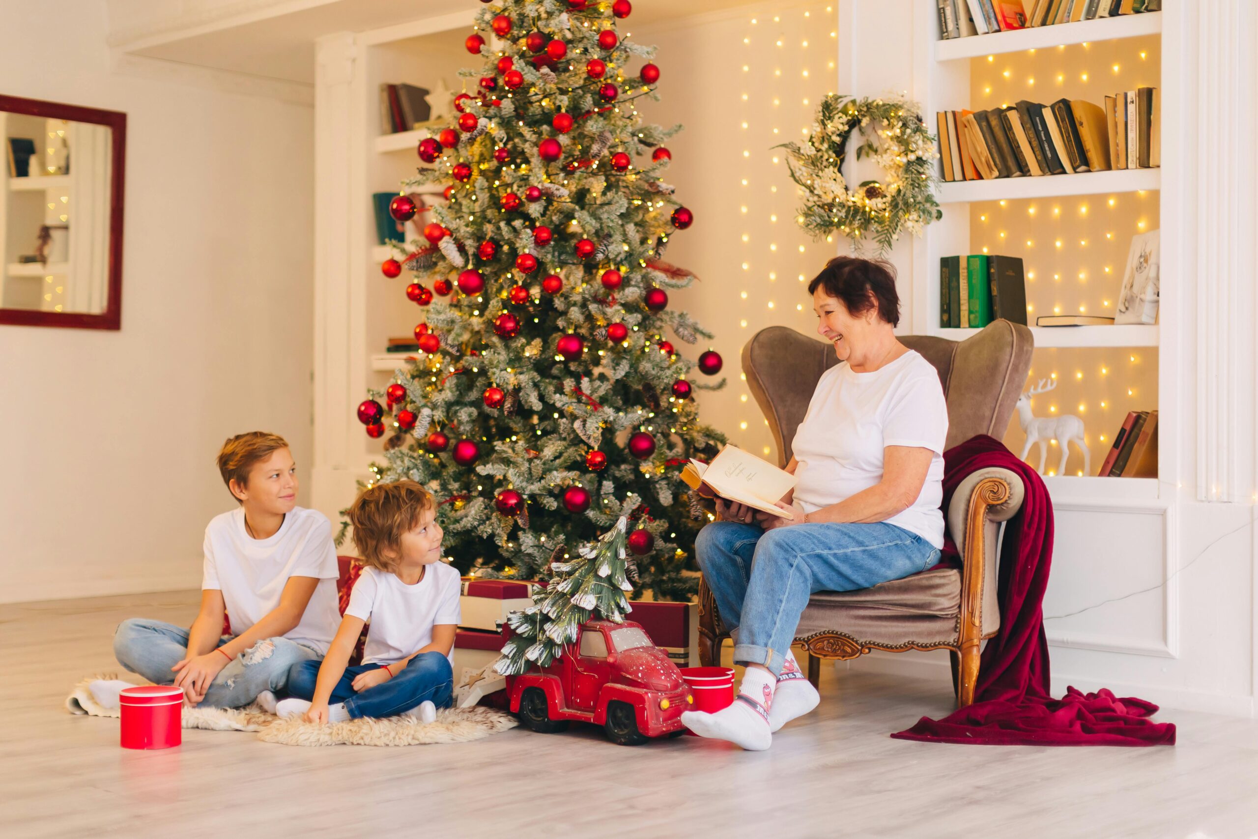 Toddler reading a Christmas Bible story beside a decorated tree